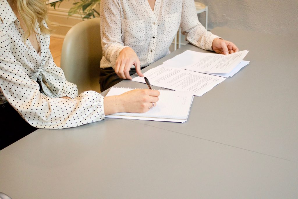women sign documents