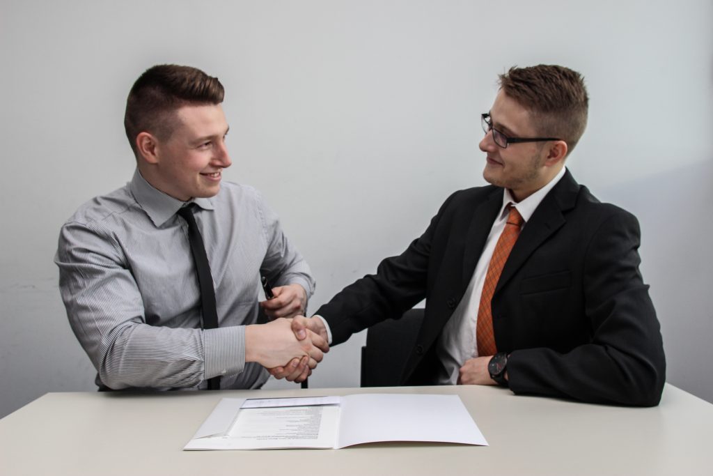 two happy men shake hands